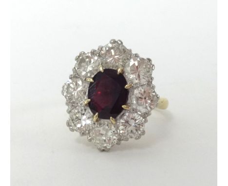 A good 18ct ruby and diamond cluster ring with central ruby stone and eight surrounding diamonds, size N.