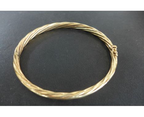 A 9ct yellow gold bangle approx 8.3 grams, 6x7cm - generally good with safety clip 