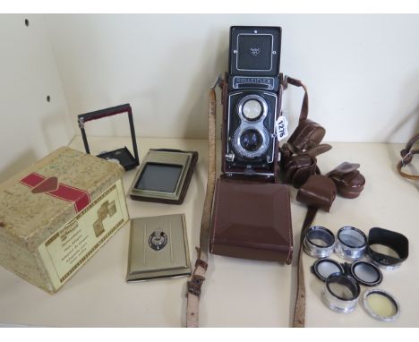 A Rolleiflex T twin lens camera wit Zeiss 75mm f 3.5 lens, lens attachments, lens cover, leather case and plate adapter 