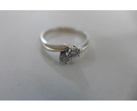 An 18ct white gold, diamond crossover, two stone, ring size O, approx 3.7 grams, diamonds bright - some usage marks 