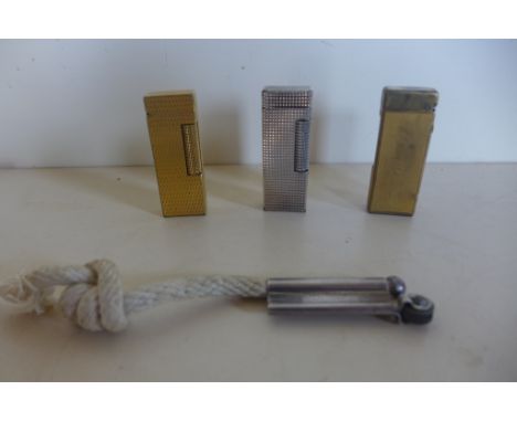 Four Dunhill lighters, including a trench silver wind proof lighter, all with usage marks