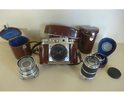 A Voitlander Prominent II camera with three lenses, and leather cases and attachments 