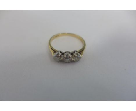 A yellow and platinum three stone diamond ring, an 18ct yellow gold band with a platinum collet, the three round brilliant di