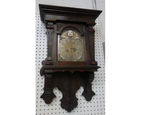 An English stained pine wall clock, late 19th century, with a stepped pediment over a silvered dial and architectural carved 