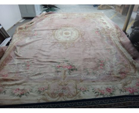 A large Austrian carpet, the plain pink field with an ivory roundel, floral spandrels, an ivory floral border, 488cm x 350cm.