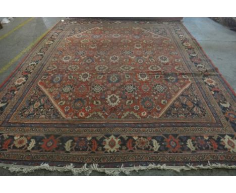 A Mahal carpet, Persian, the madder field with an allover design of palmette and floral sprays, black matching spandrels, a b