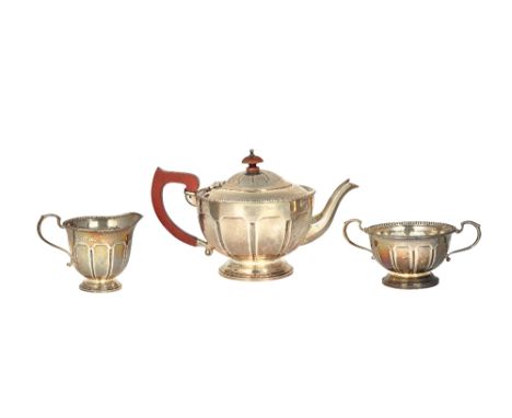 A silver three piece tea set, comprising; a teapot, a twin handled sugar bowl and a milk jug, each piece of circular form, wi