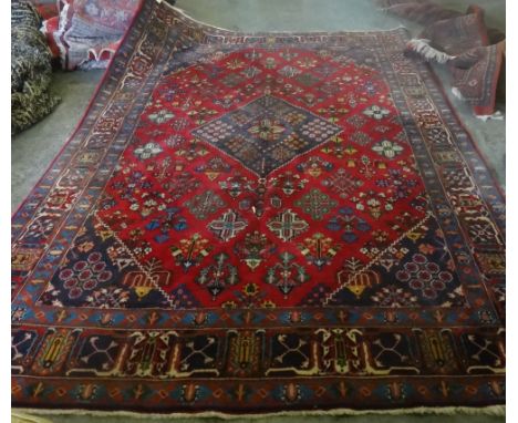 A Maymeh carpet, Persian, the madder field with an indigo diamond, with matching spandrels, floral diamond motifs, an indigo 