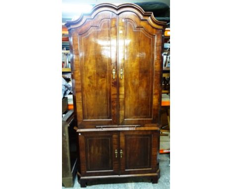 An 18th century Dutch inlaid mahogany floor standing corner cupboard, the bonnet top over two pairs of panel cupboards divide