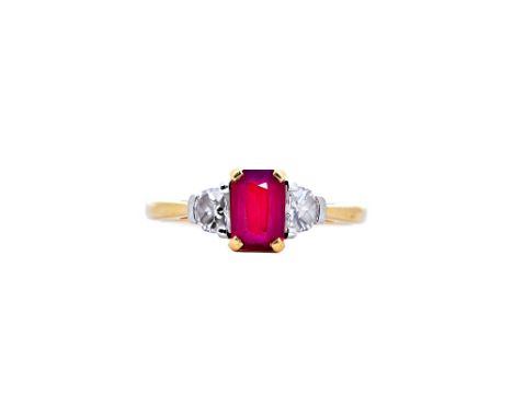 An 18ct gold, ruby and diamond three stone ring, claw set with a central cushion cut ruby, weight approx. 1.1cts, between two