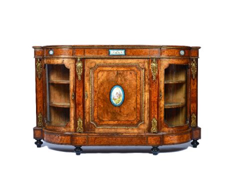 A Victorian gilt metal mounted figured walnut credenza, with ceramic mounted central panel door, flanked by glazed rounded do