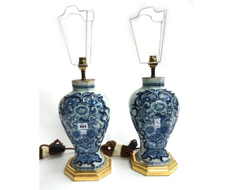 A pair of Dutch Delft tin glaze vases, converted to table lamps, circa 1740, each foliate decorated against a segmented balus