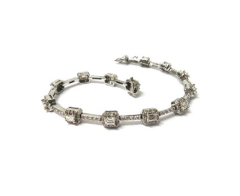 An 18ct white gold and diamond bracelet, formed as a series of cut cornered square clusters, each centred by an emerald cut d