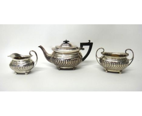 A late Victorian silver three piece tea set, comprising; a teapot, a twin handled sugar bowl and a milk jug, each piece with 