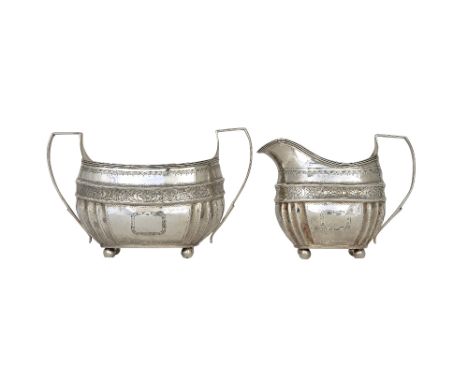 A George III silver twin handled sugar bowl, of curved form, with partly fluted decoration, beneath a foliate engraved band, 