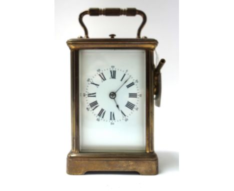A French brass cased carriage clock, late 19th century, with visible escapement, push repeat, and white enamel dial with a tw