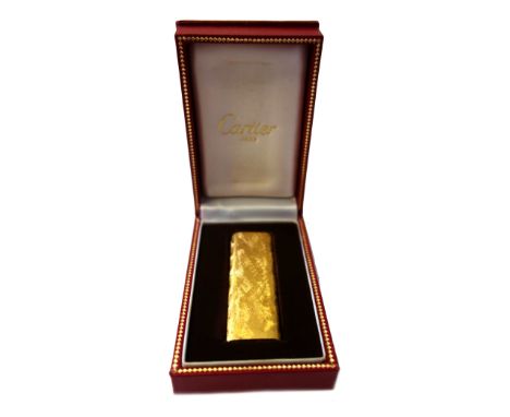 Cartier; a gold plated lighter, with textured finish, signed, numbered 177350, 7cm long, cased.
