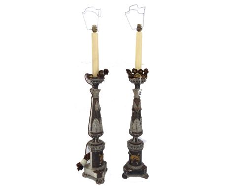A pair of Italian painted and gilt pricket candlesticks, later adapted as lamp bases, 65cm high, extending fitments. (2)