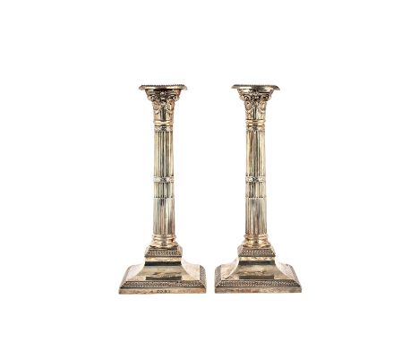 A pair of Victorian silver table candlesticks, each of classical column form, with fluted decoration, raised on a square base