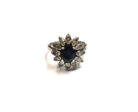 A gold and platinum, sapphire and diamond set flowerhead shaped cluster ring, claw set with the oval cut sapphire in a surrou