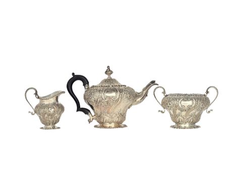 A late Victorian silver three piece tea set, comprising; a teapot, a twin handled sugar bowl and a milk jug, each piece of pe