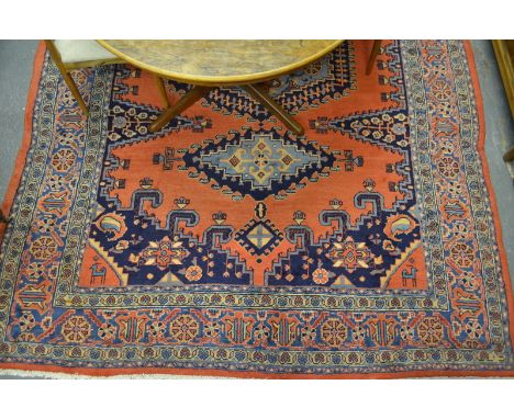 A Persian Sarouk carpet, the mid blue geometric centre medallion on pale red ground, 3.40 x 2.35 m