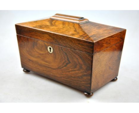 A Victorian rosewood sarcophagus tea caddy raised on ball feet
