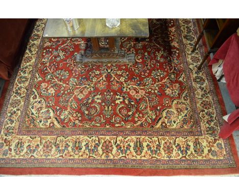 A Persian Mahal carpet, circa 1970s, the design of trailing vines around a centre medallion on red ground, 3.72 x 2.70 m