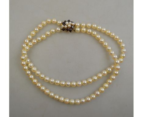 A two row cultured pearl choker of uniform size on 9ct yellow gold garnet and cultured pearl snap, fitted with safety catch t