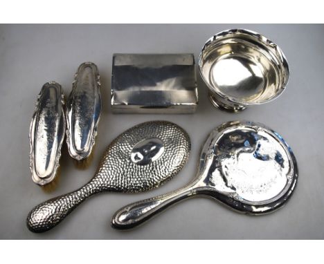 An engine-turned silver cigarette box, Birmingham 1936, a stemmed sugar basin, Birmingham 1912, a hand-mirror and two brushes