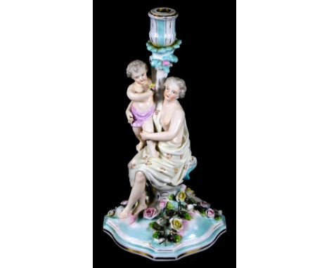 A 20thC continental porcelain candlestick group, formed as a lady semi-clad aside child, on a floral base, polychrome decorat