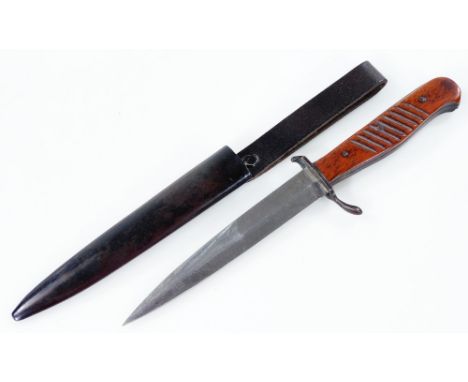 A Commando knife, with turned wooden handle and metal scabbard, 27cm W.