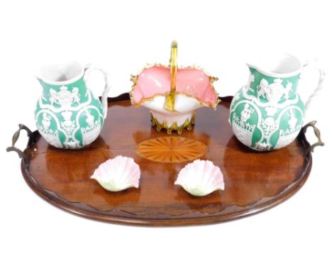 An Edwardian mahogany Sheraton revival tea tray, of oval form, with galleried edge and metal handles, centred by an oval shel