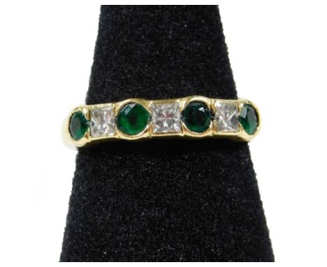 A modern emerald and diamond half hoop eternity ring, set with four round cut emeralds and three square cut diamonds, all in 