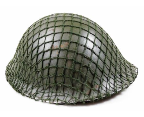 A 20thC tin army helmet, in green with netting, interior leather section and chin strap, 17cm H, interior measurements 20cm x