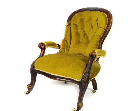 A Victorian mahogany spoon back chair, with carved floral top, overstuffed button back arms and seat, on inverted turned cabr