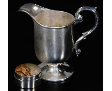 An Edwardian silver cream jug, with a helmet shaped bowl, S scroll handle, inverted stem and circular foot, Birmingham 1907, 