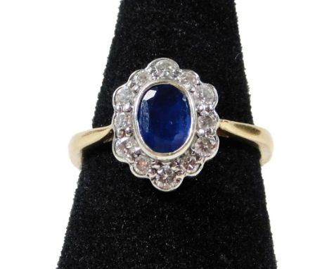 A modern 9ct gold sapphire and diamond cluster ring, with central oval cut sapphire, measuring 6.4mm x 4.6mm x 2.6mm, totalli