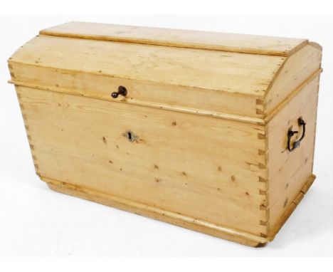 A late 19thC pine domed top trunk, with side carrying handles and visible dovetails, with shaped hinged lid and plain interio