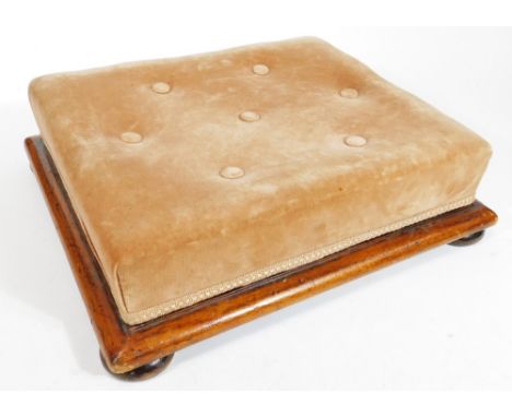 A Victorian mahogany framed footstool, with overstuffed button top, in fawn material on compressed bun feet, 15cm H, 41cm W, 