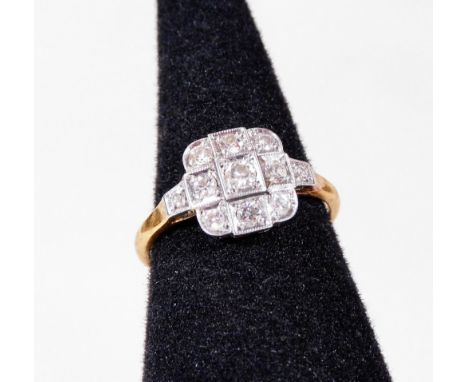 An Art Deco diamond dress ring, set with round brilliant cut diamonds, in platinum setting, on a plain design band, marked 18