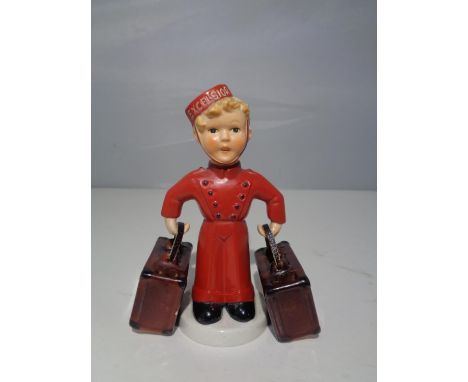 A GOEBEL FIGURINE OF A BELLHOP BOY AND SUITCASES 