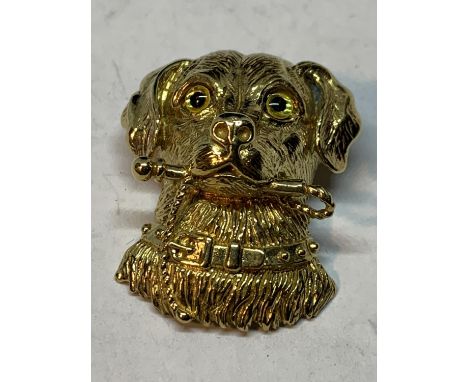 A SILVER GILT PENDANT IN THE FORM OF A DOGS HEAD WITH A STICK 