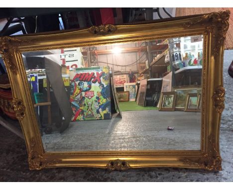 A LARGE ORNATE GILT FRAMED MIRROR 87CM X63CM 