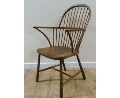 Comb back Windsor chair with scrolled arms, saddle seat raised on turned supports united by stretcher.106cm high &amp; 56cm w