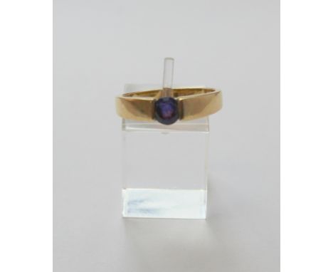 Gold band ring with purple sapphire in gold tension style setting '750'. Size 'R'.&nbsp;4g. 