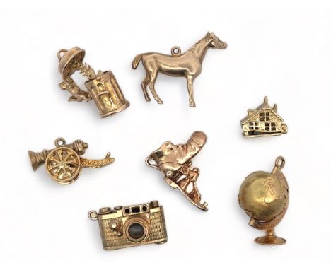 A range of seven charms, five fully hallmarked 9ct gold, two (globe and cannon unmarked). Also includes a cat with dustbin, h