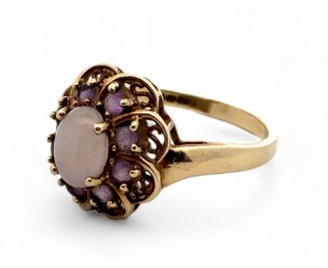 An amethyst and white cabochon stone cluster ring, hallmarked 9ct gold. Size R. Weight 3.58g. Please see the buyer's terms an