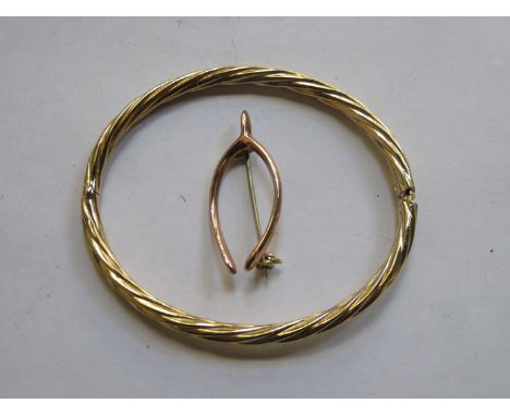 9ct GOLD WISHBONE BROOCH AND GOLD COLOURED SNAP BANGLE 