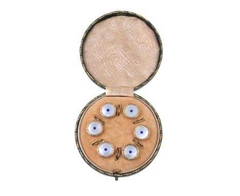 ϒAn early 20th century 9 carat gold mother of pearl button dress set, the circular panels of mother of pearl each set with a 